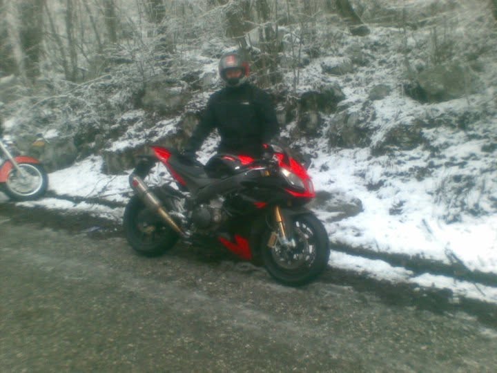 Motociclista con una sportiva rossa sulla neve